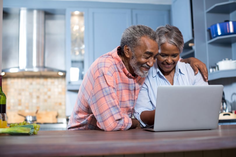 A senior couple using a laptop to plan for their future care.