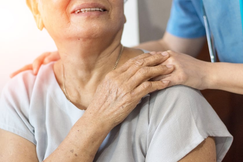 caregiver and resident holding hands