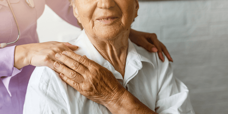 Elderly female hand holding the hand of young caregiver at senior living home