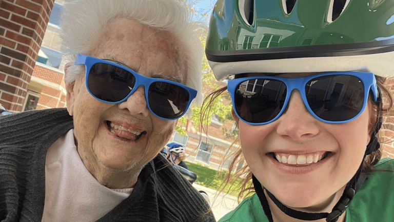 Two older adults riding a bike